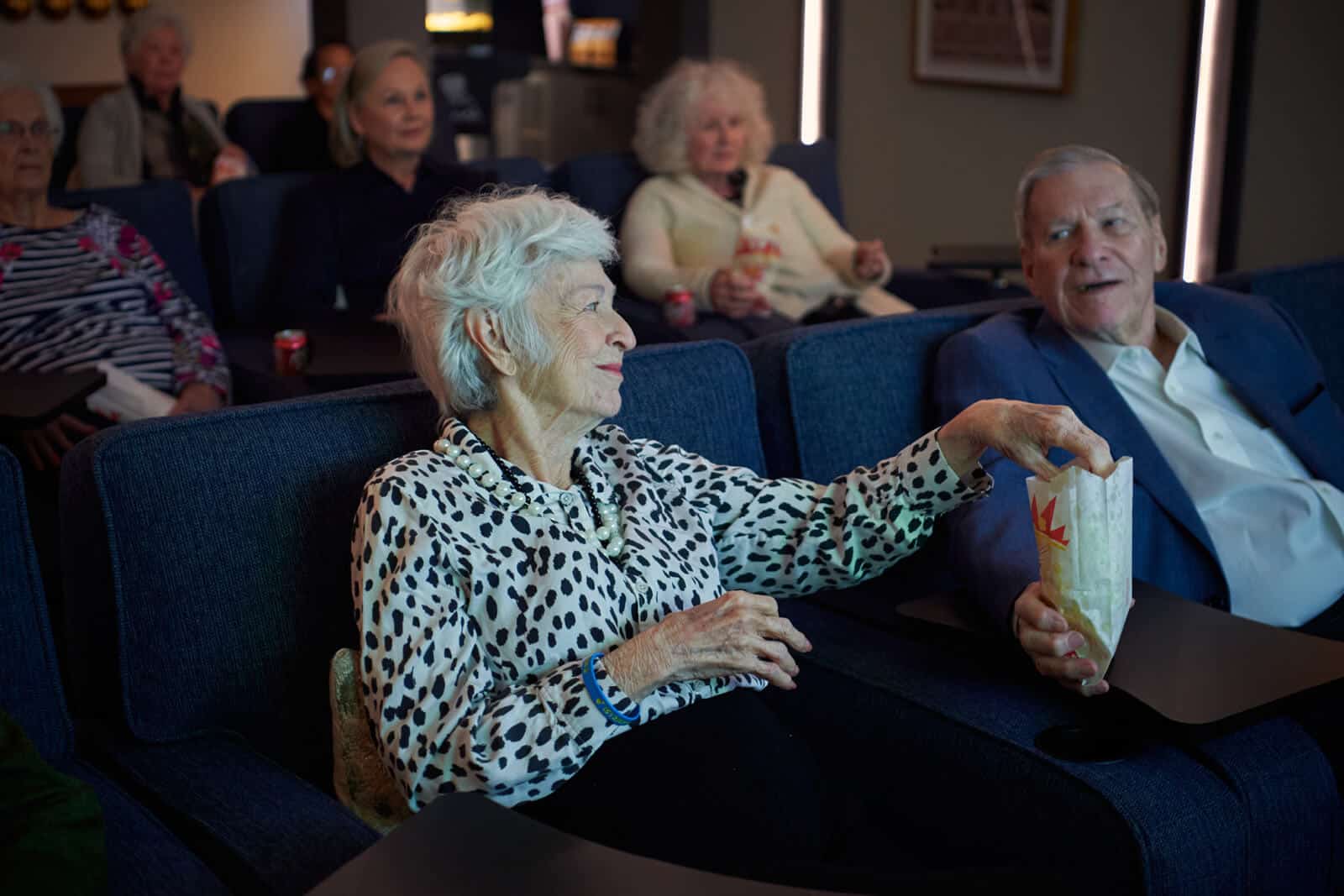 residents eating popcorn and watching a movie