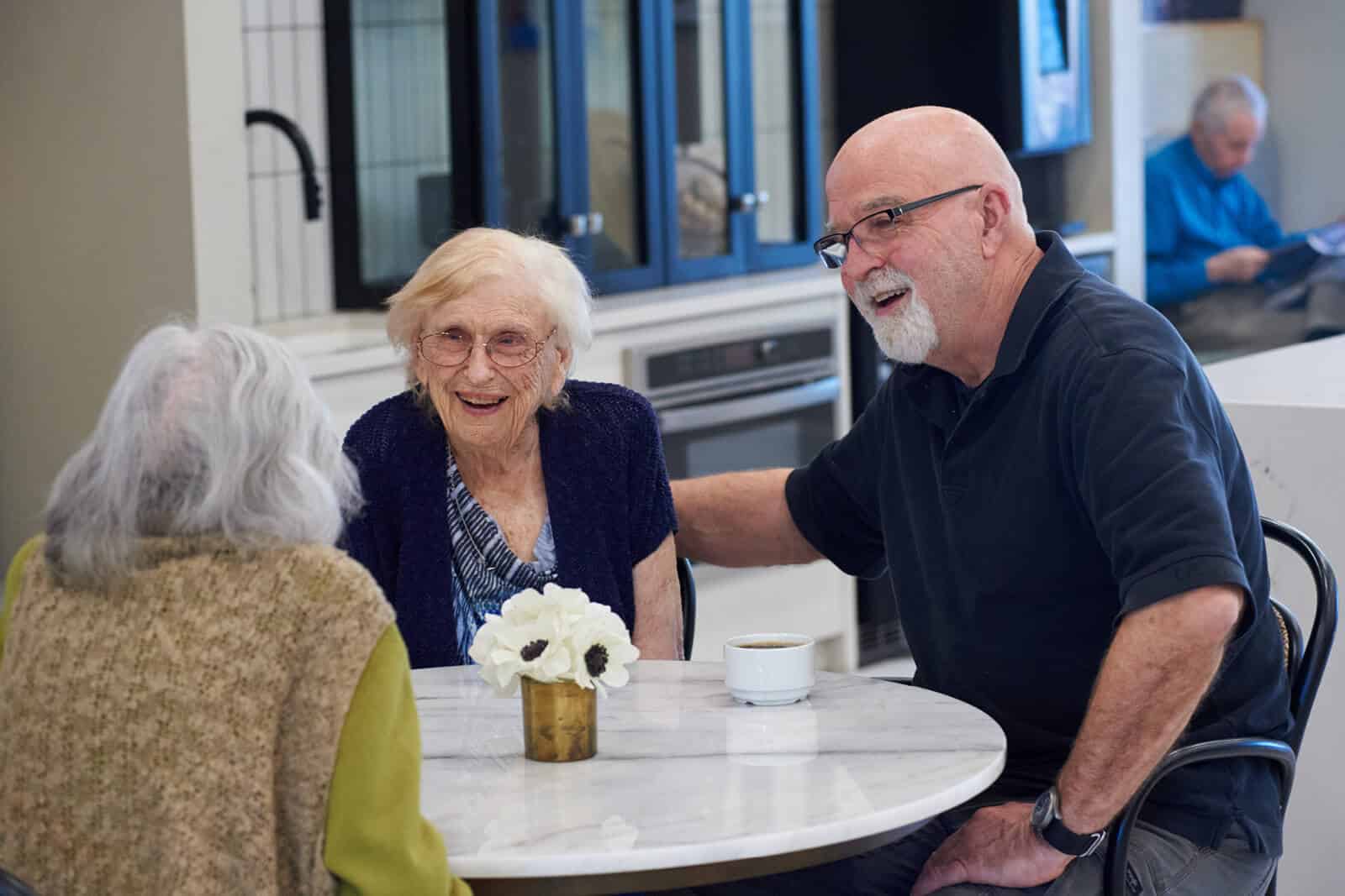 3 people sitting at a table enjoying coffee