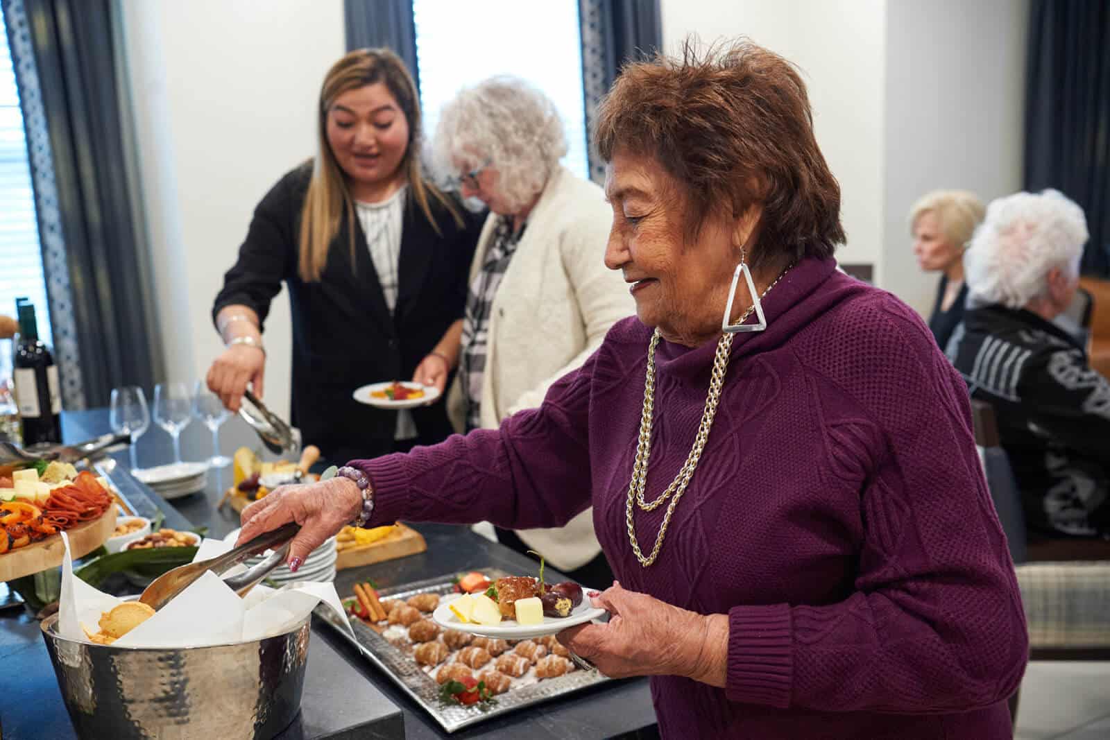 Resident getting cheese and fruit from event buffet