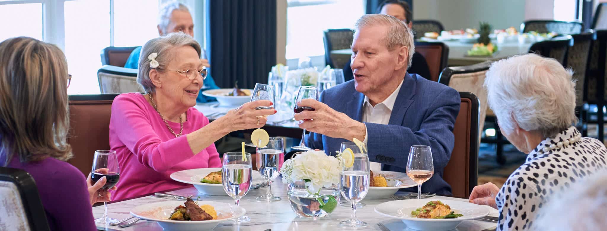 friends clinking wine glasses at dinner