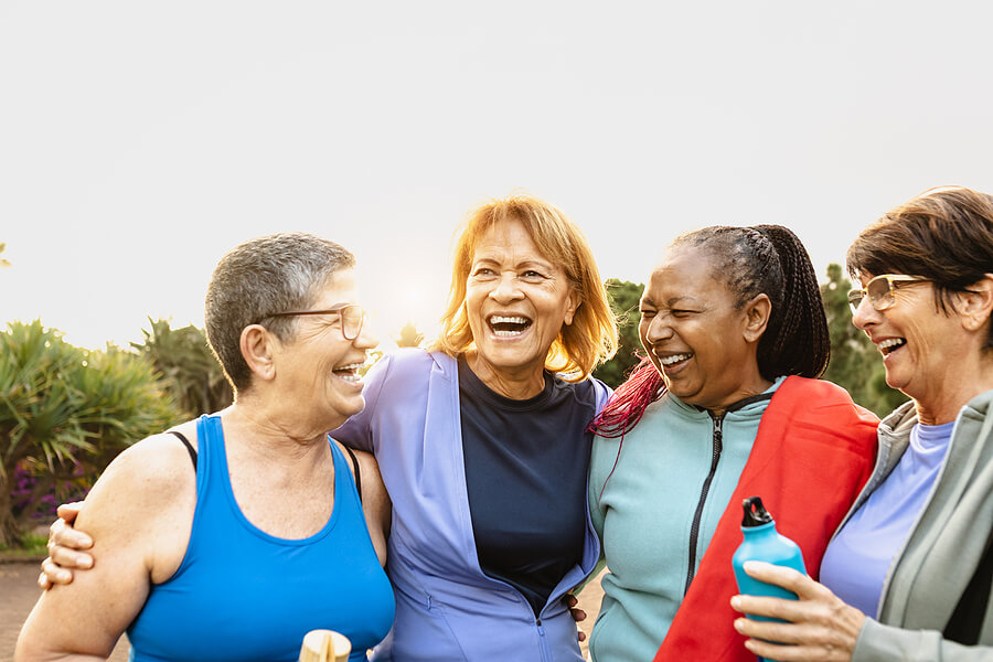 A group of older senior women laughing together outside