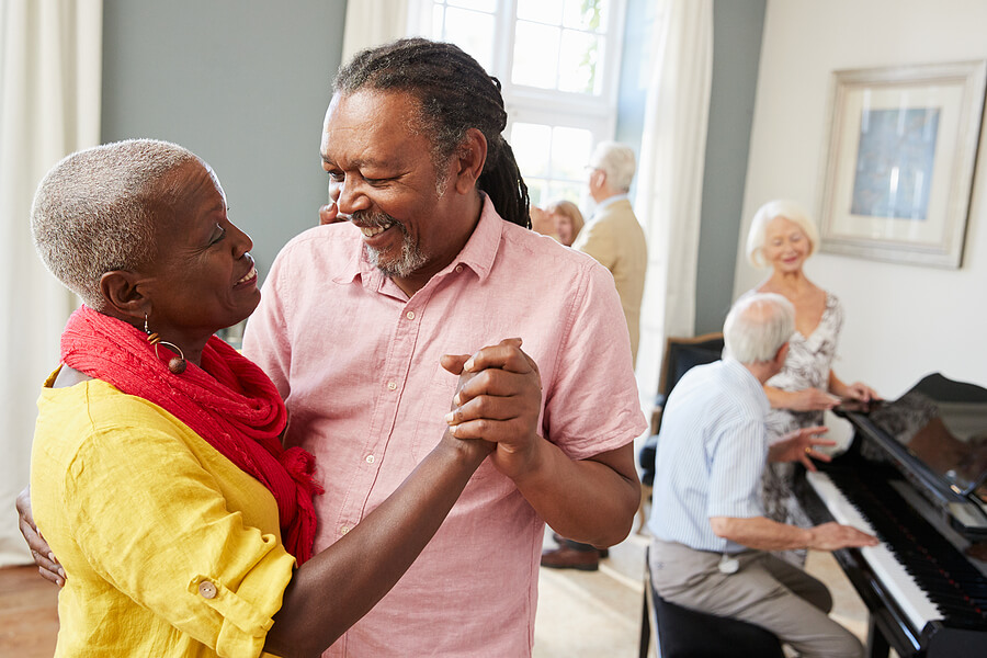 A senior couple dancing with other seniors in the background