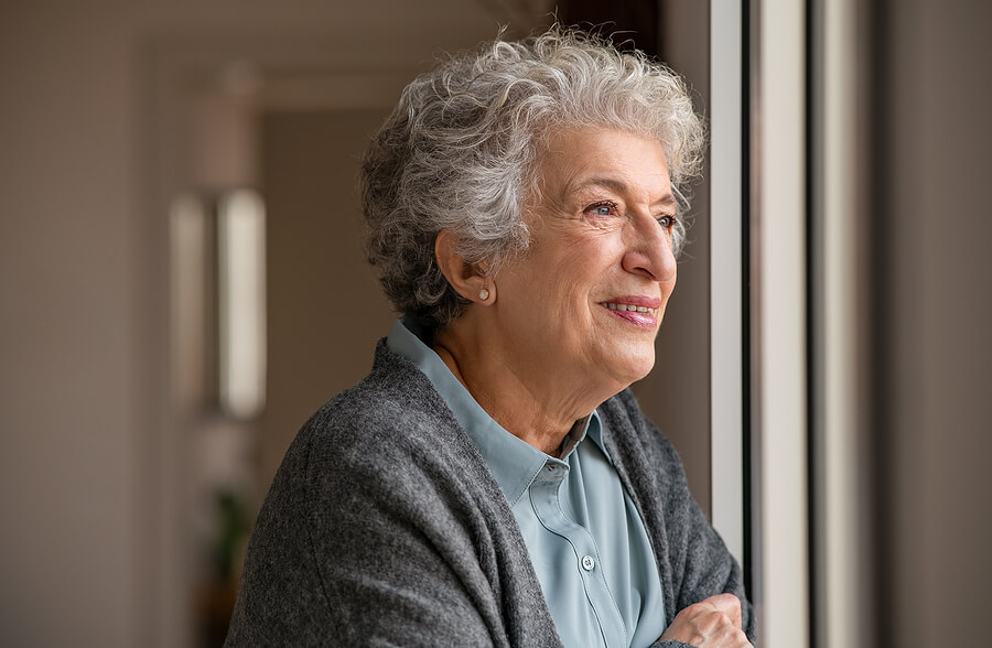 Senior woman looking outside a window