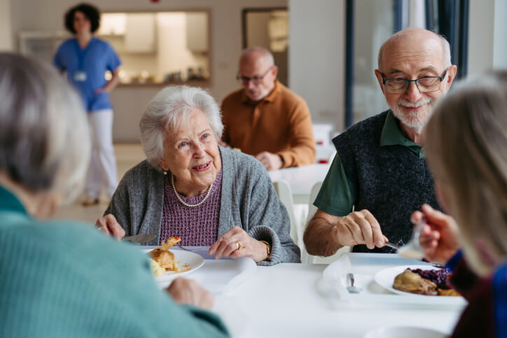 A group of seniors are dining together while in conversation