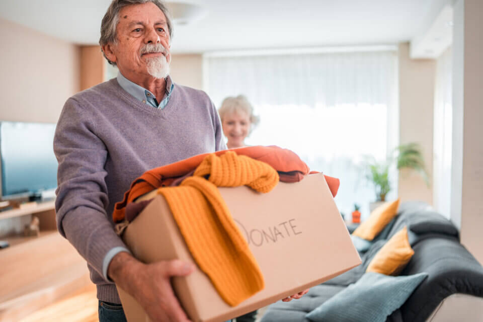 A senior man carrying a donation box